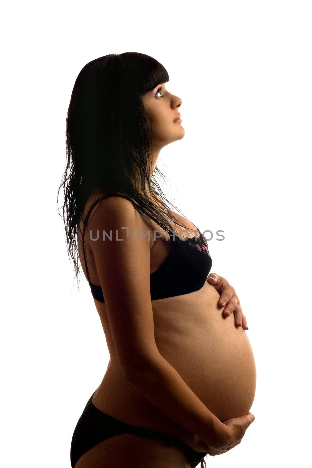 Pregnant young brunette in black lingerie. Isolated