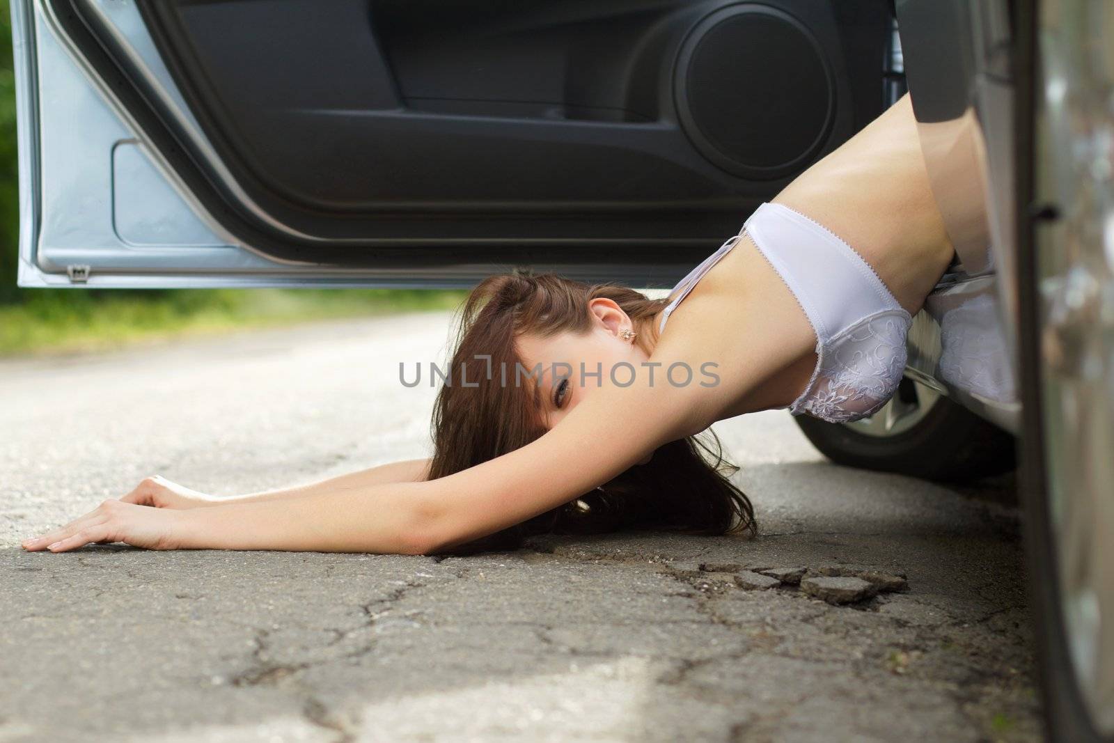 Sexy young woman lying on the road