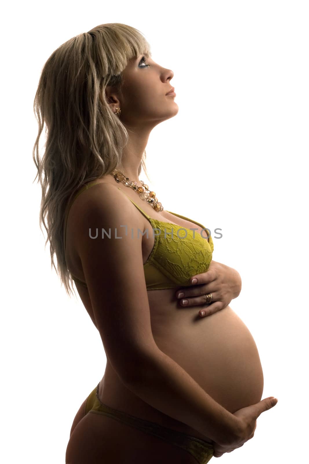 Pregnant young woman in yellow lingerie. Isolated on white