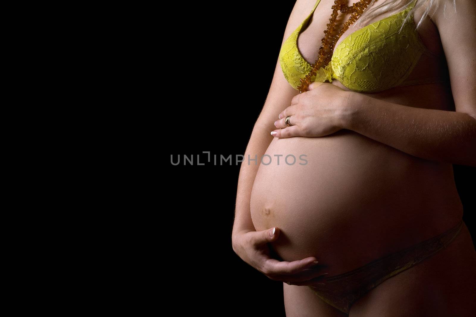 Belly of a pregnant girl. Isolated on black