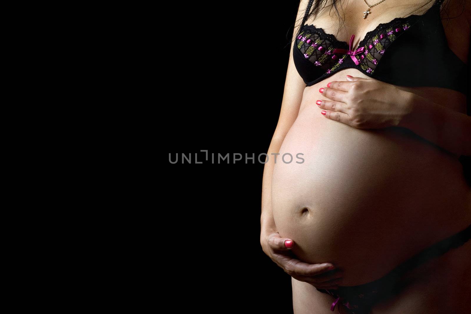 Belly of a pregnant woman. Isolated on black