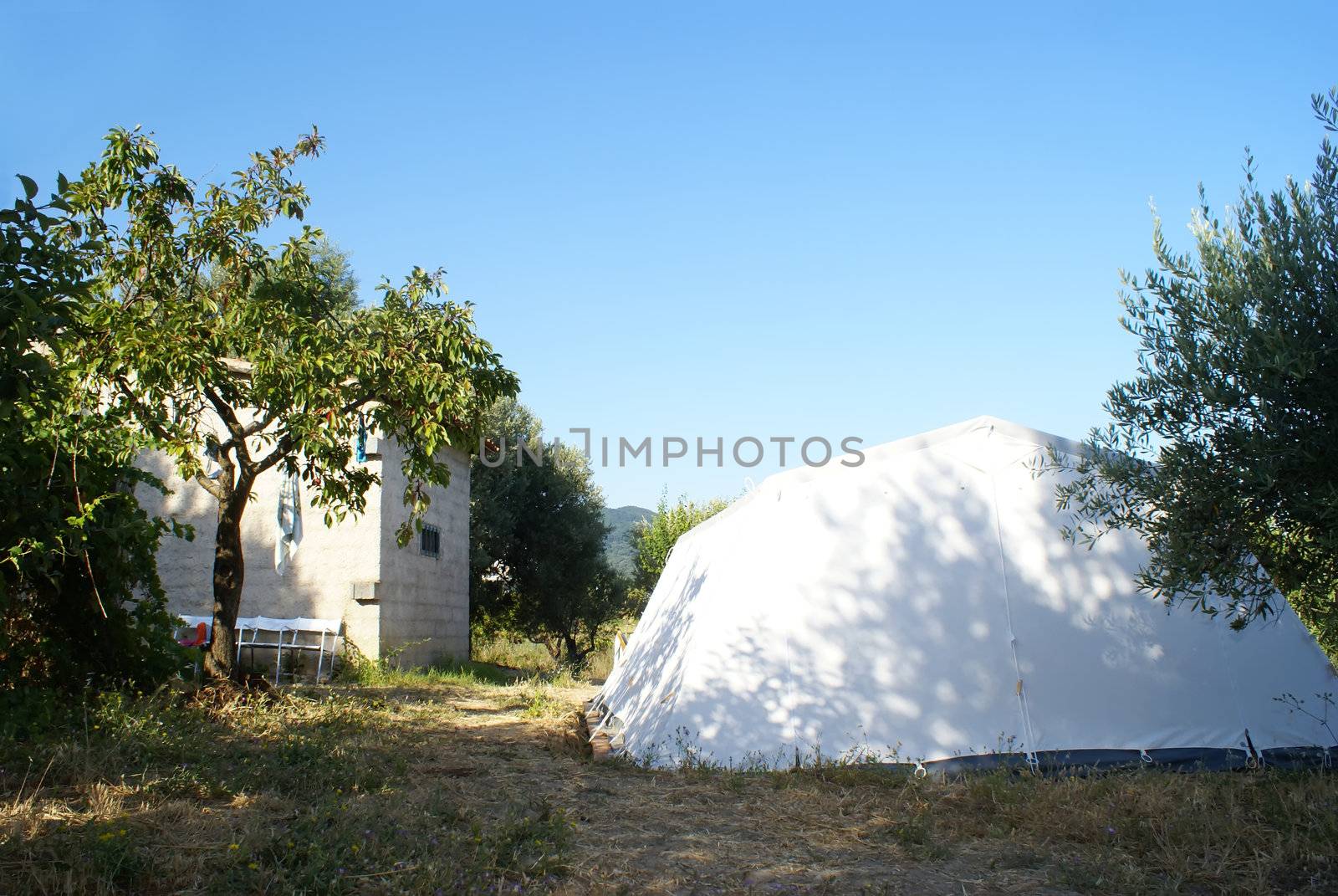 large camping tent in the countryside over blue sky