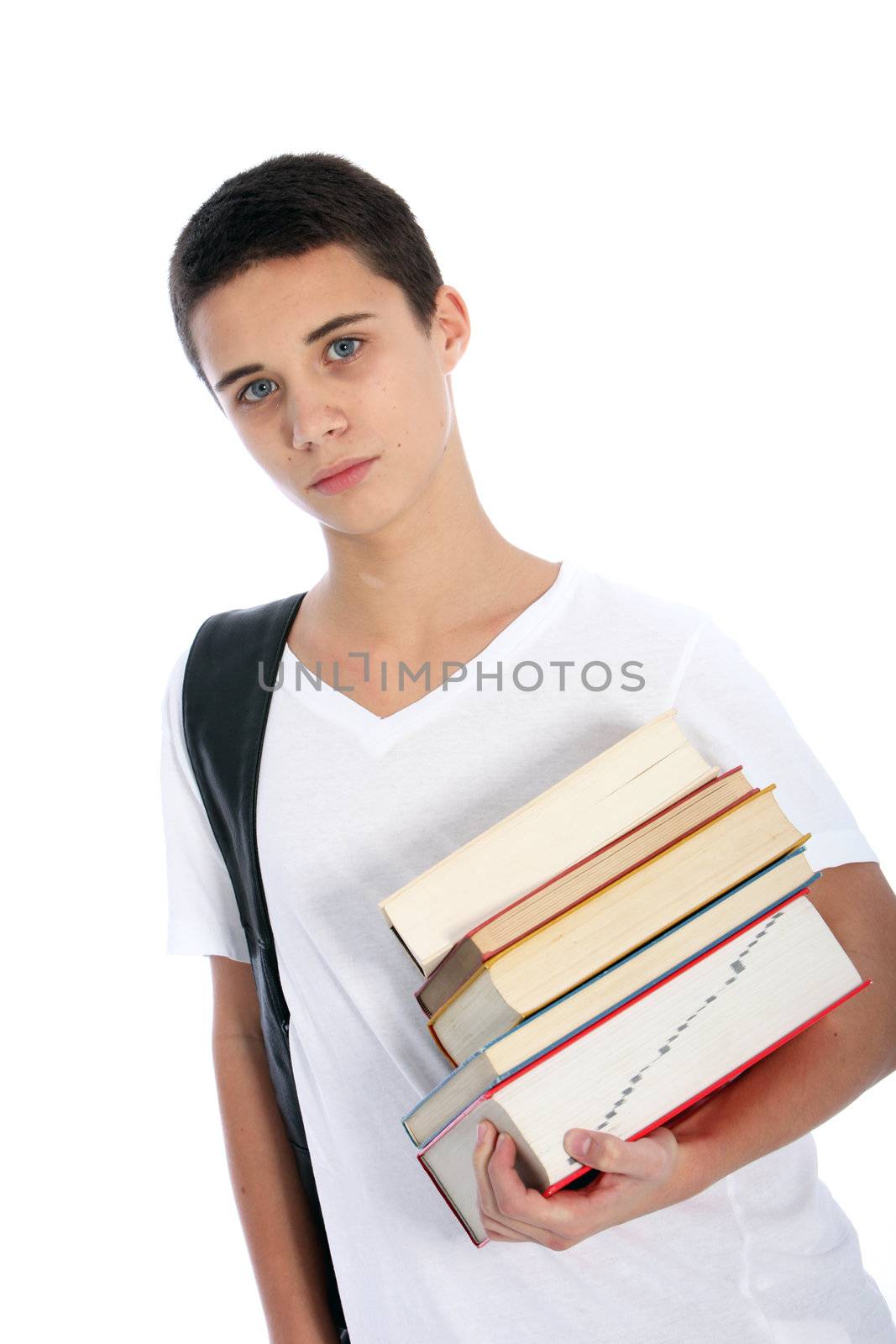 Serious young teenaged boy carrying a stack of textbooks on his arm and a bag over his shoulder as he prepares to go to college isolated on white