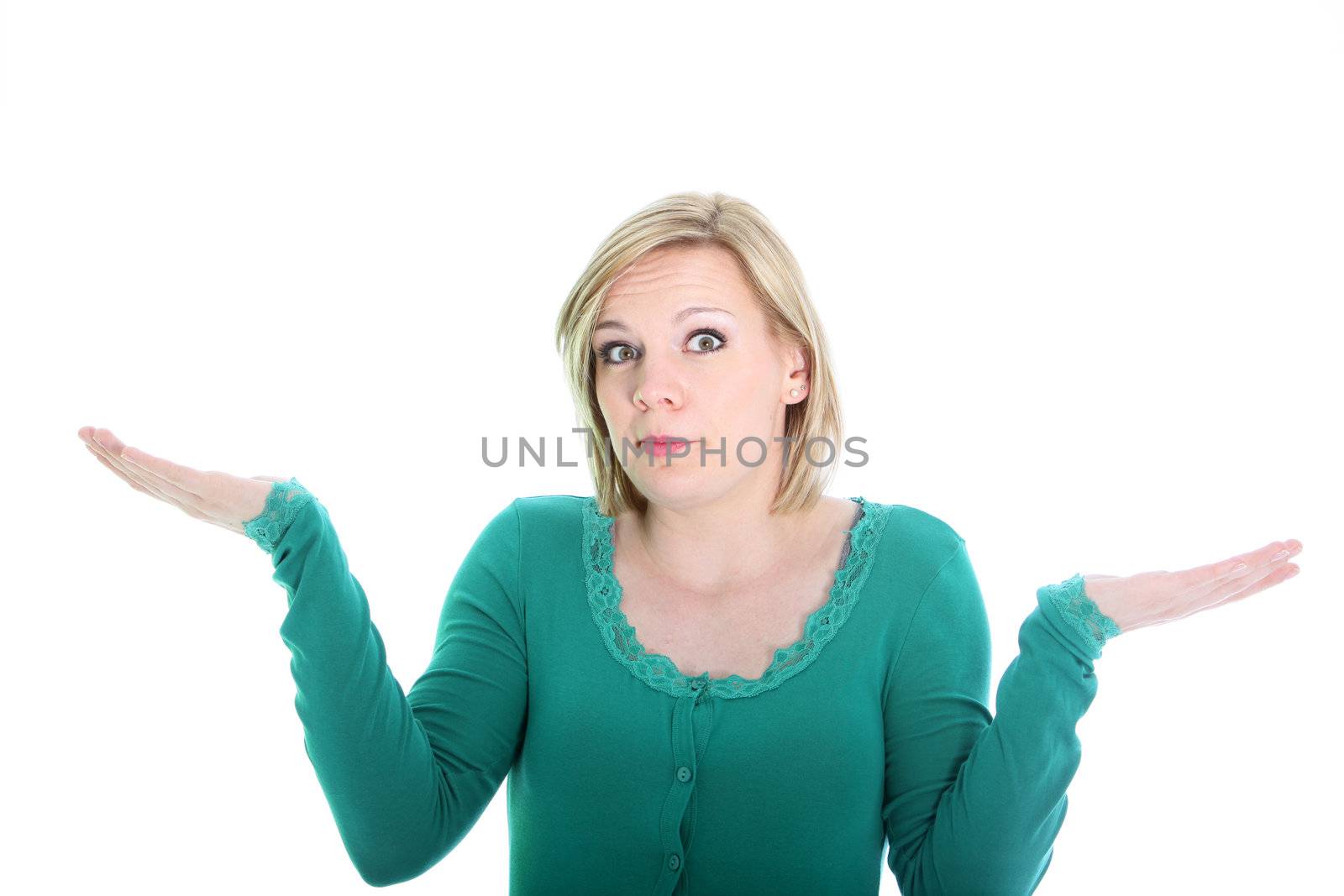 Ignorant young blonde woman with a wide eyed expression shrugging her shoulders in ignorance or indifference isolated on white