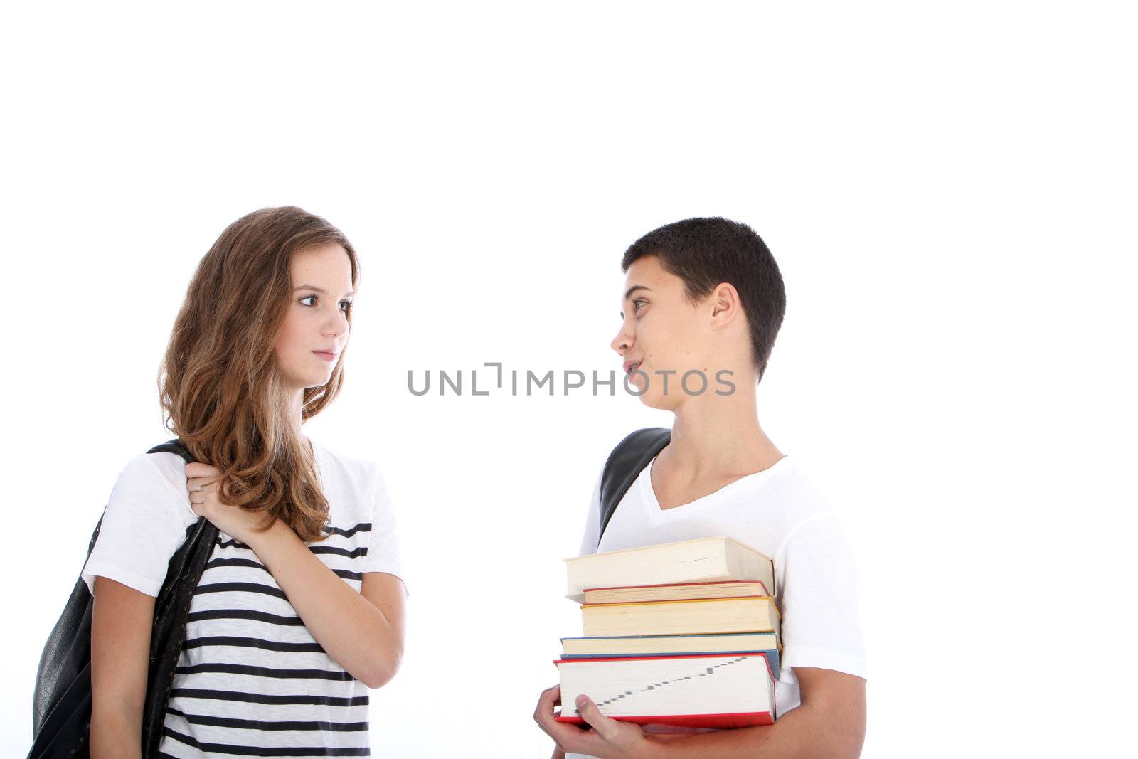 Teenage student girl looking to a teenage student boy holding his books Teenage student girl looking to a teenage student boy holding his books