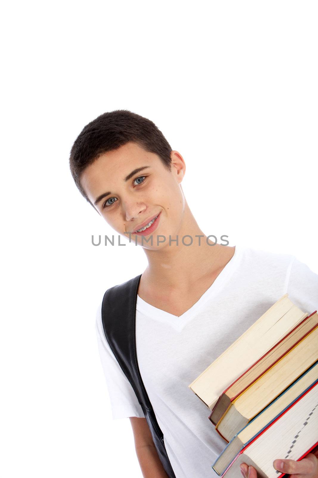 Smiling attractive young teenage boy carrying a pile of books under his arm as he makes his way to classes at college isolated on white