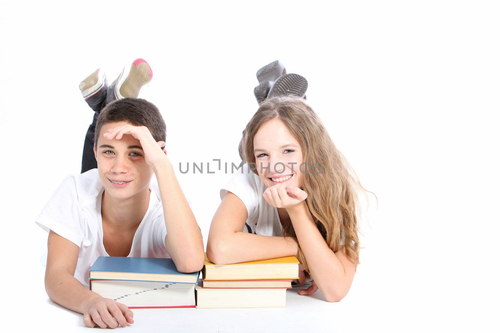 Teenage boy and girl isolated on white in studio smiling with text books