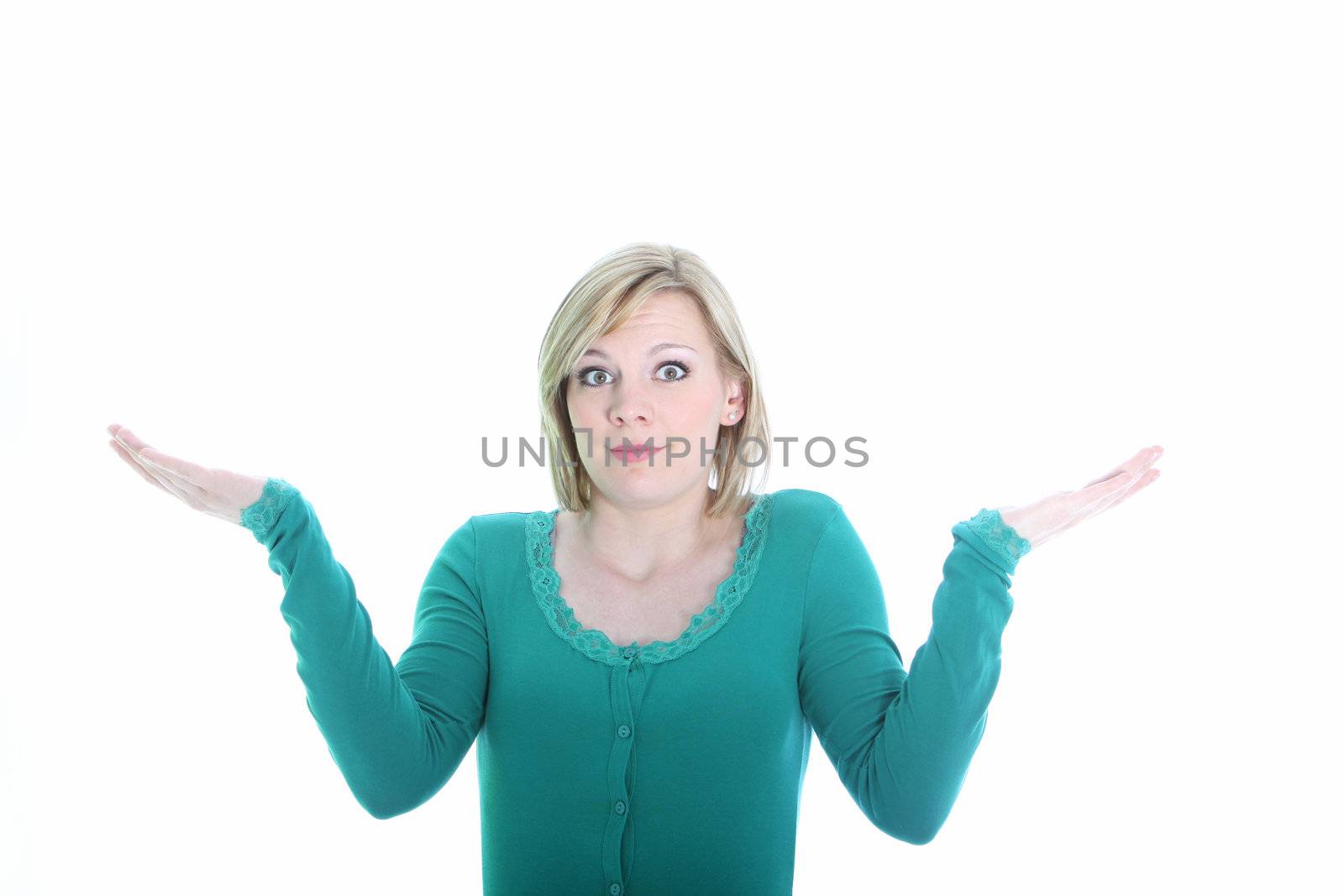 Woman shrugs in indifference raising her hands in the air with wide open eyes isolated on white