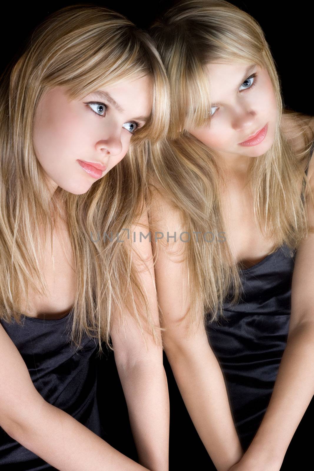 Portrait of the young blonde near a mirror