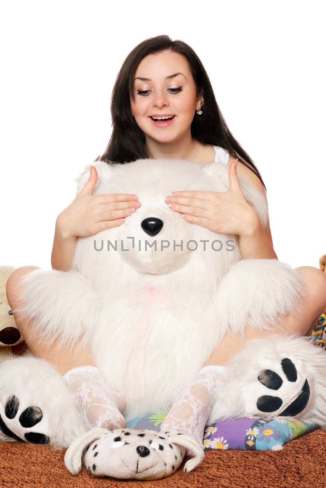 Pretty girl plays with a big teddy bear