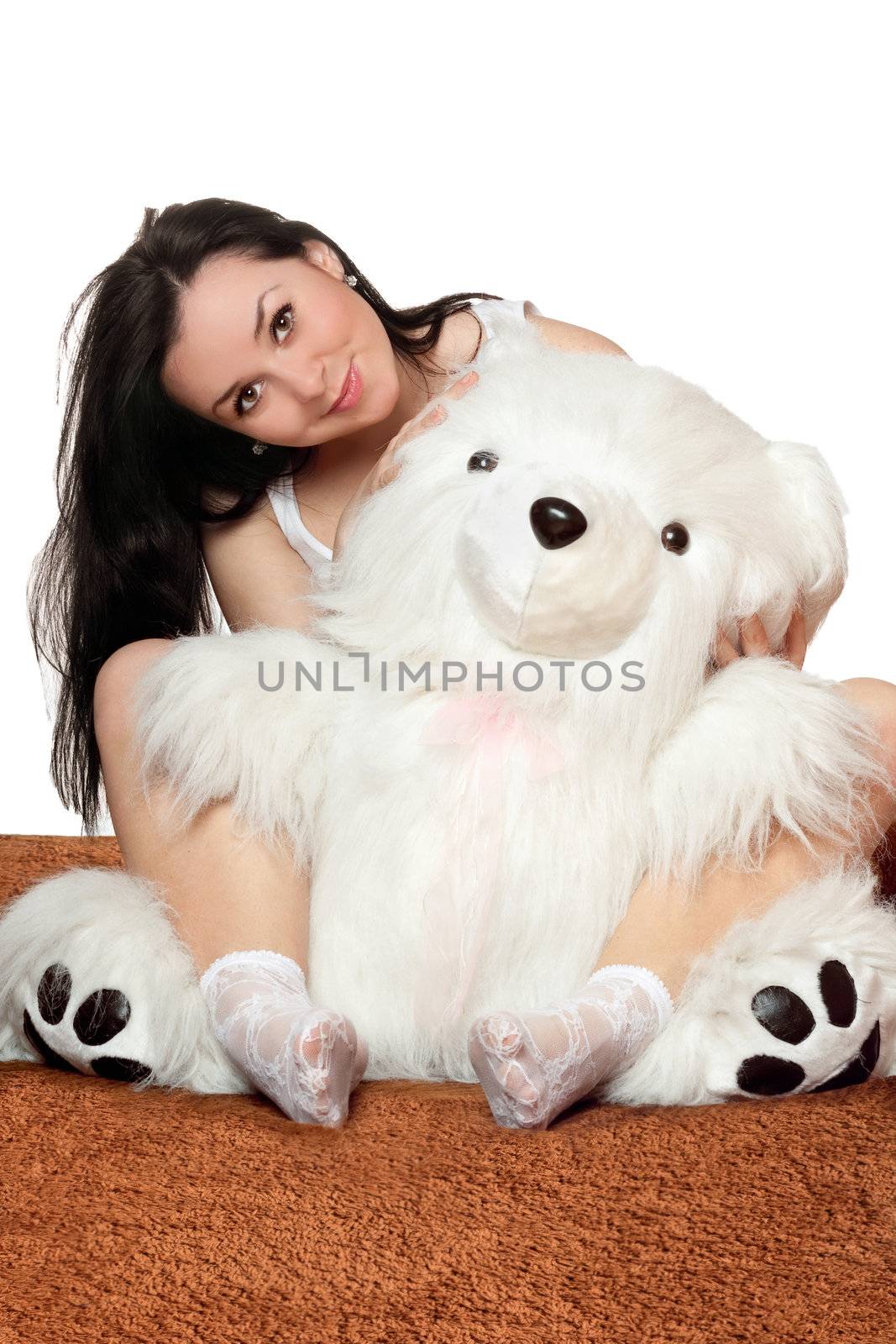 Lovely girl sitting in an embrace with a large teddy bear