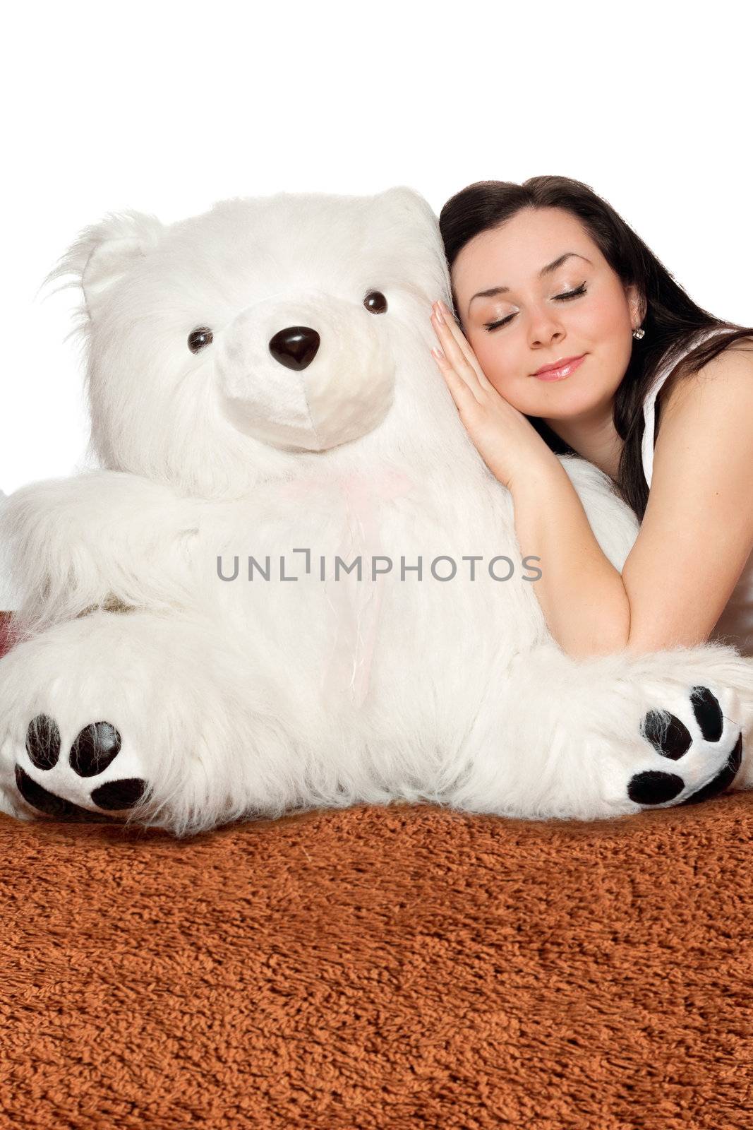 Girl asleep leaning against a big teddy bear