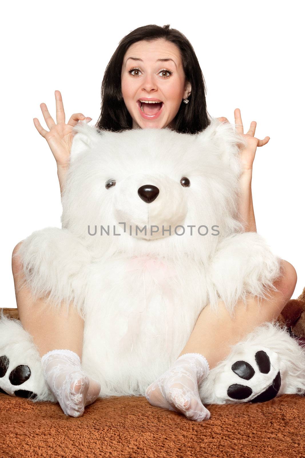 Cheerful girl plays with a big teddy bear