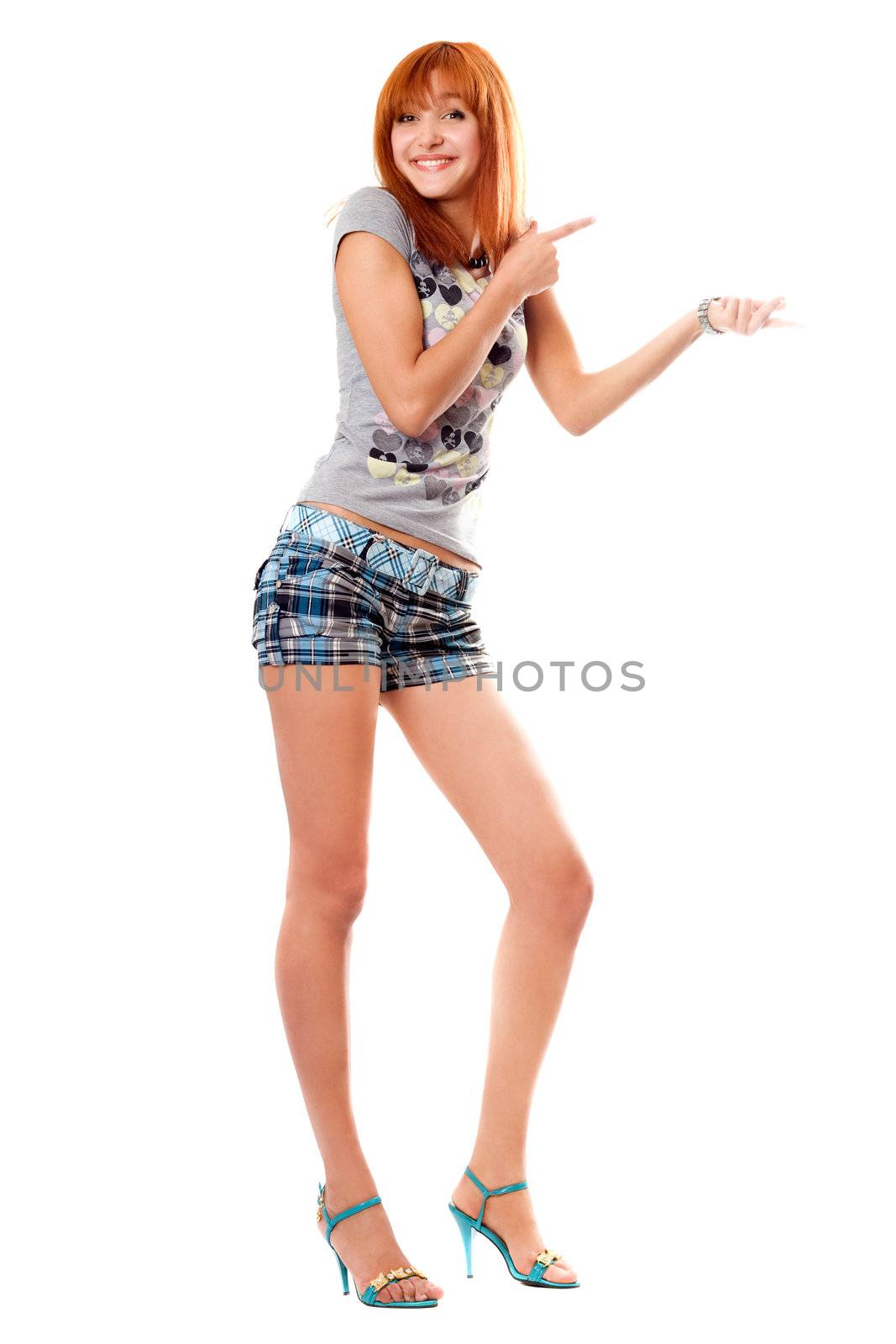 Cheerful red-haired girl in a t-shirt and shorts. Isolated on white