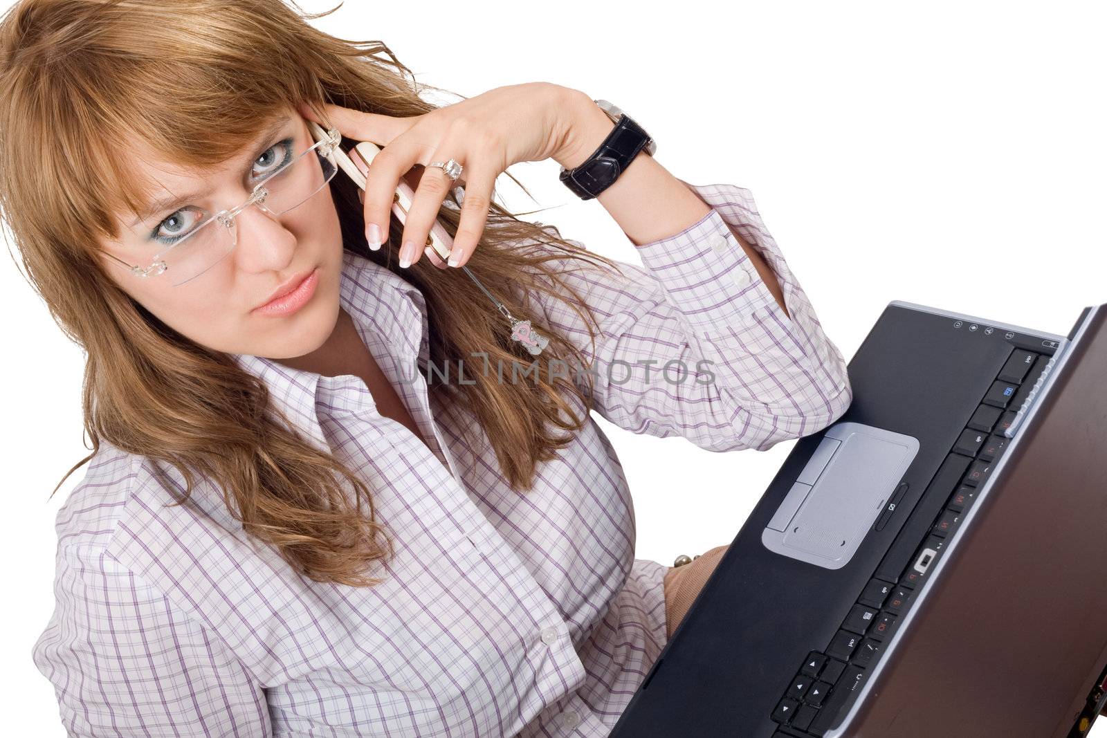 The young woman in glasses sits with the laptop and phone. Isolated