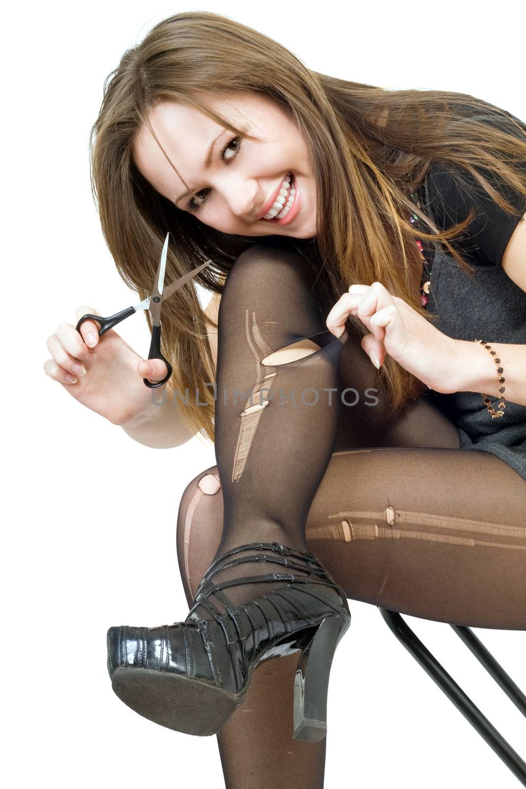 Smiling girl with scissors cuts the stockings. Isolated
