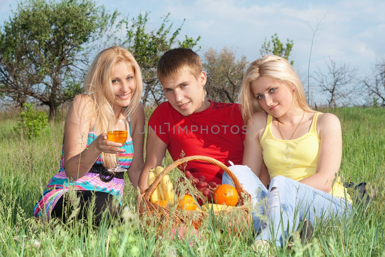 Two attractive blonde and young man outdoors