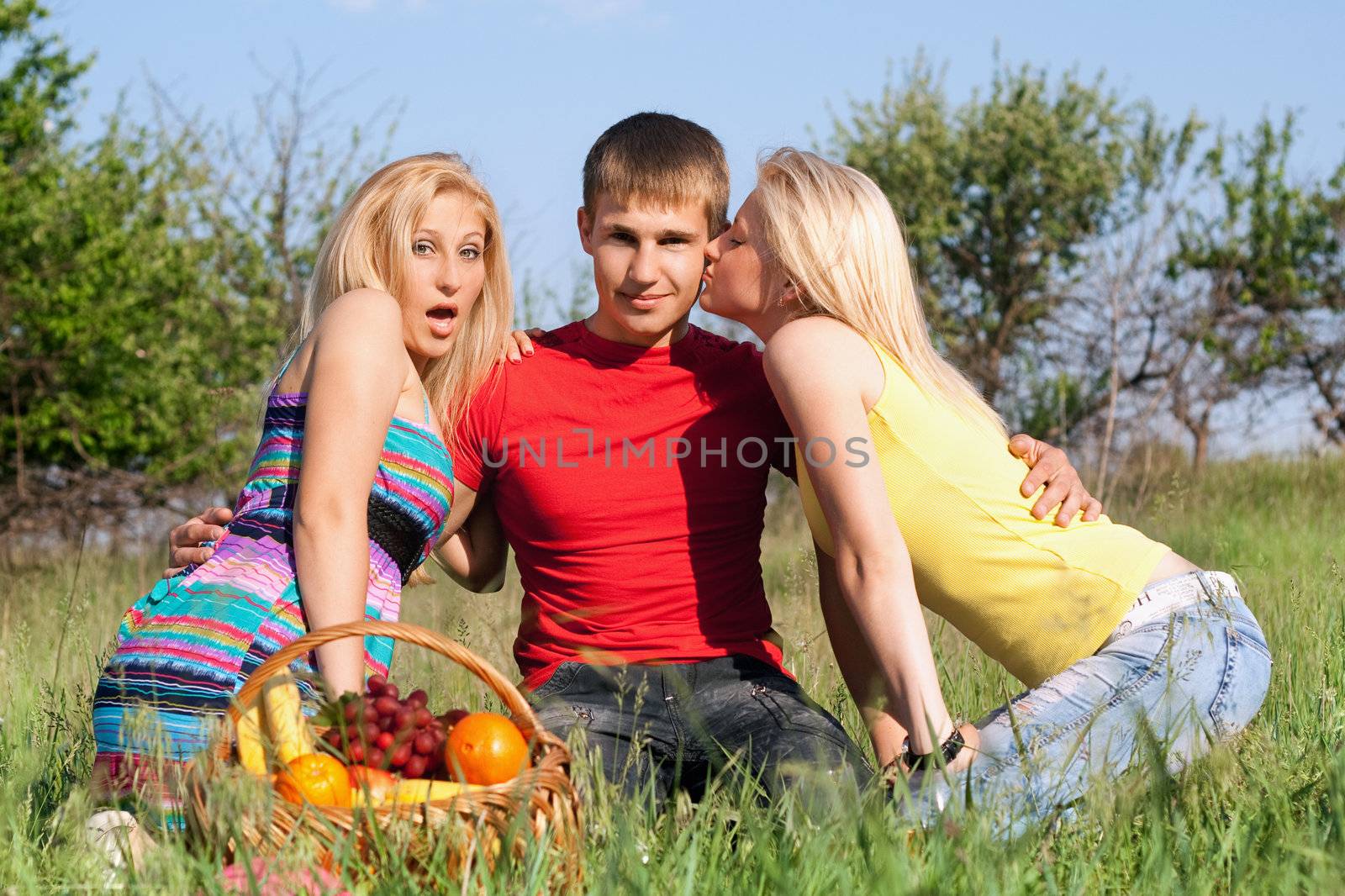 Two beautiful blonde and young man outdoors