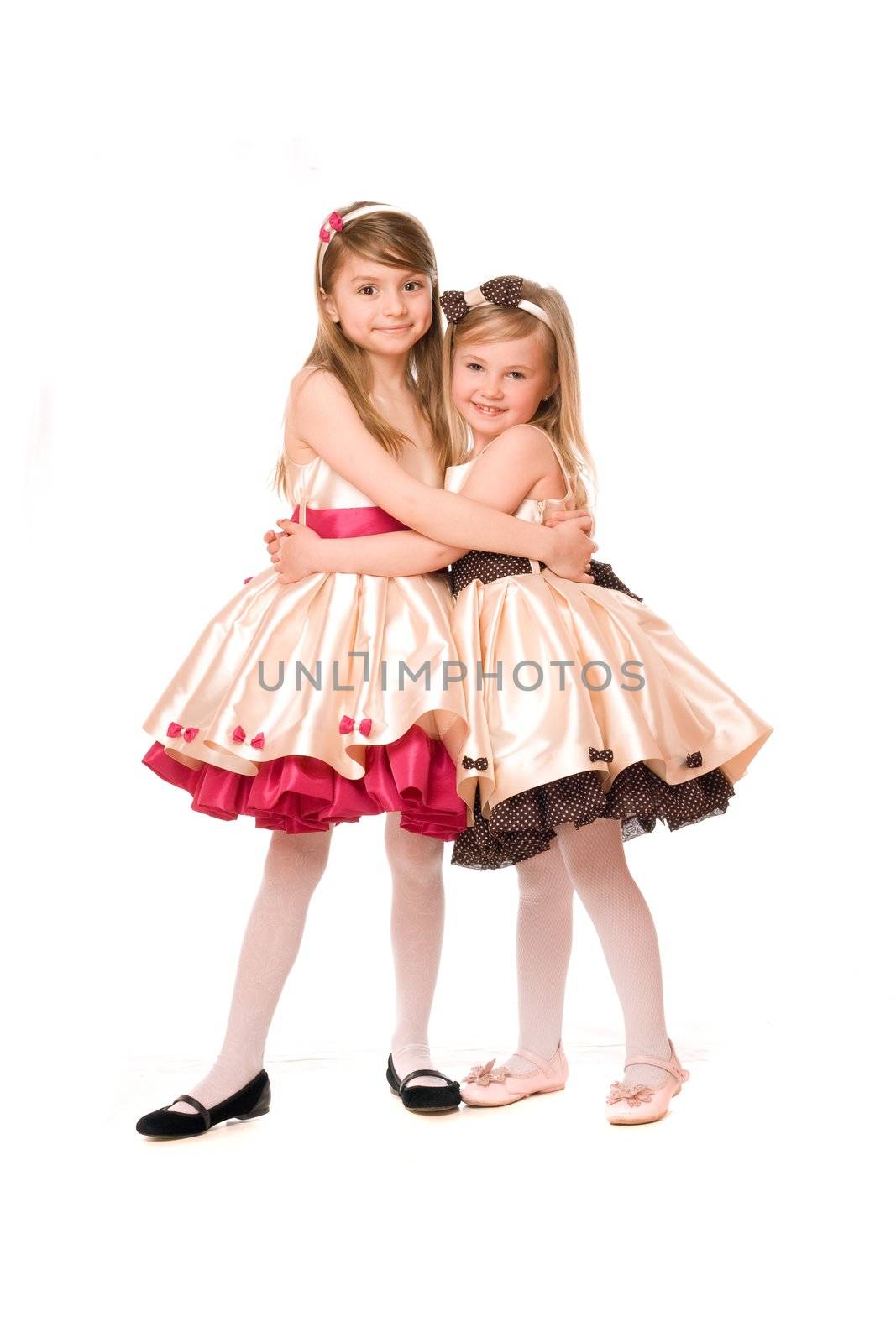 Two attractive little girls in a dress. Isolated