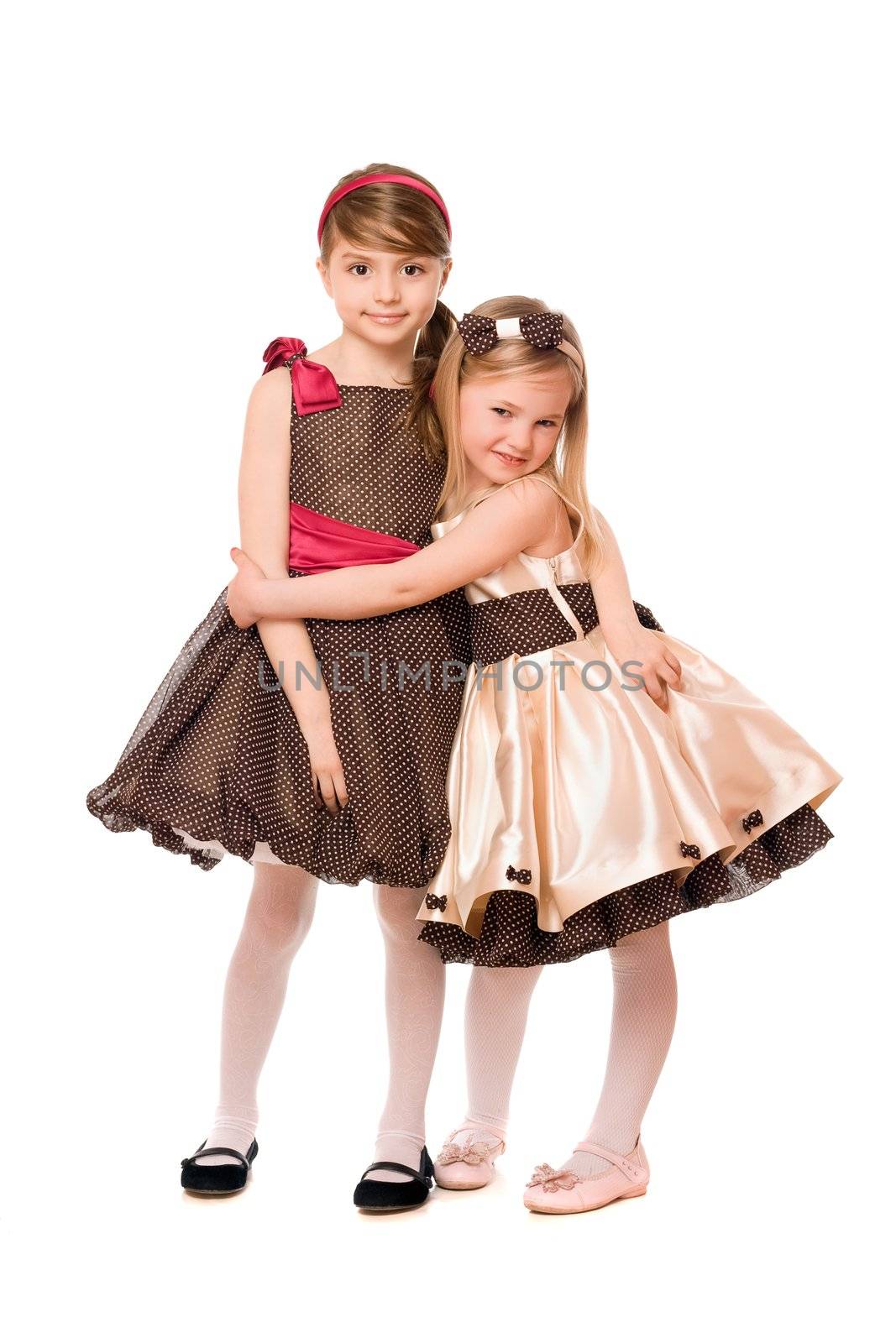 Two cute little girls in a dress. Isolated on white