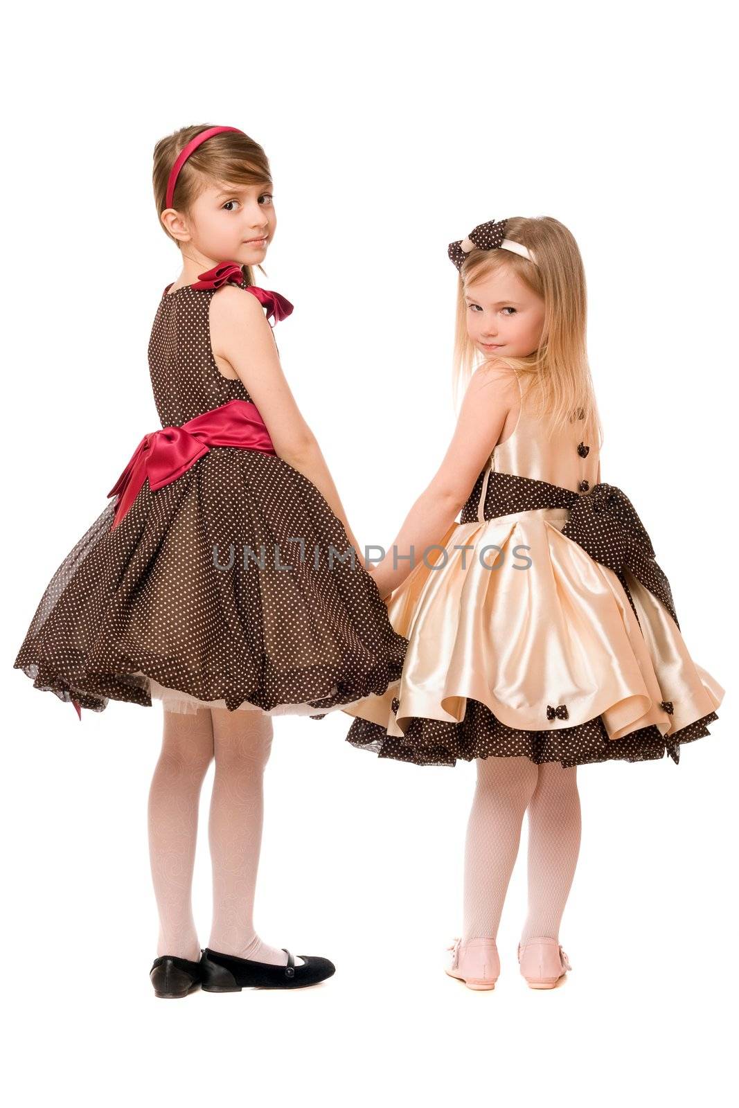 Two little girls in a dress. Isolated on white