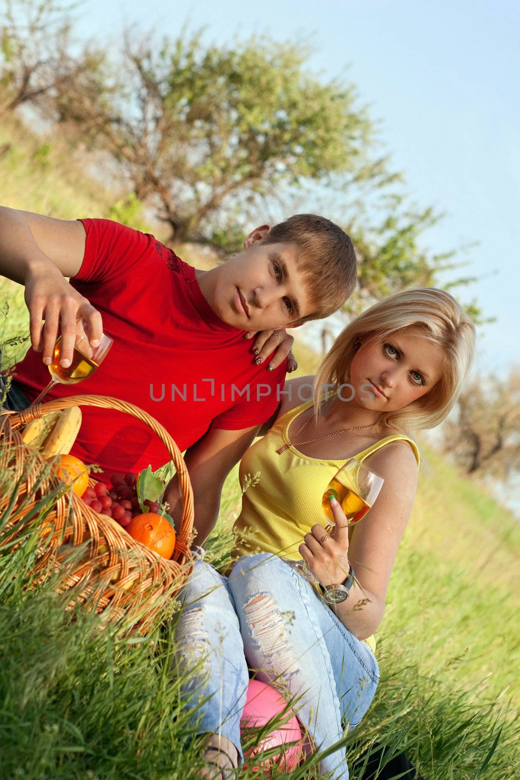 Attractive blonde and young man with wineglasses outdoors