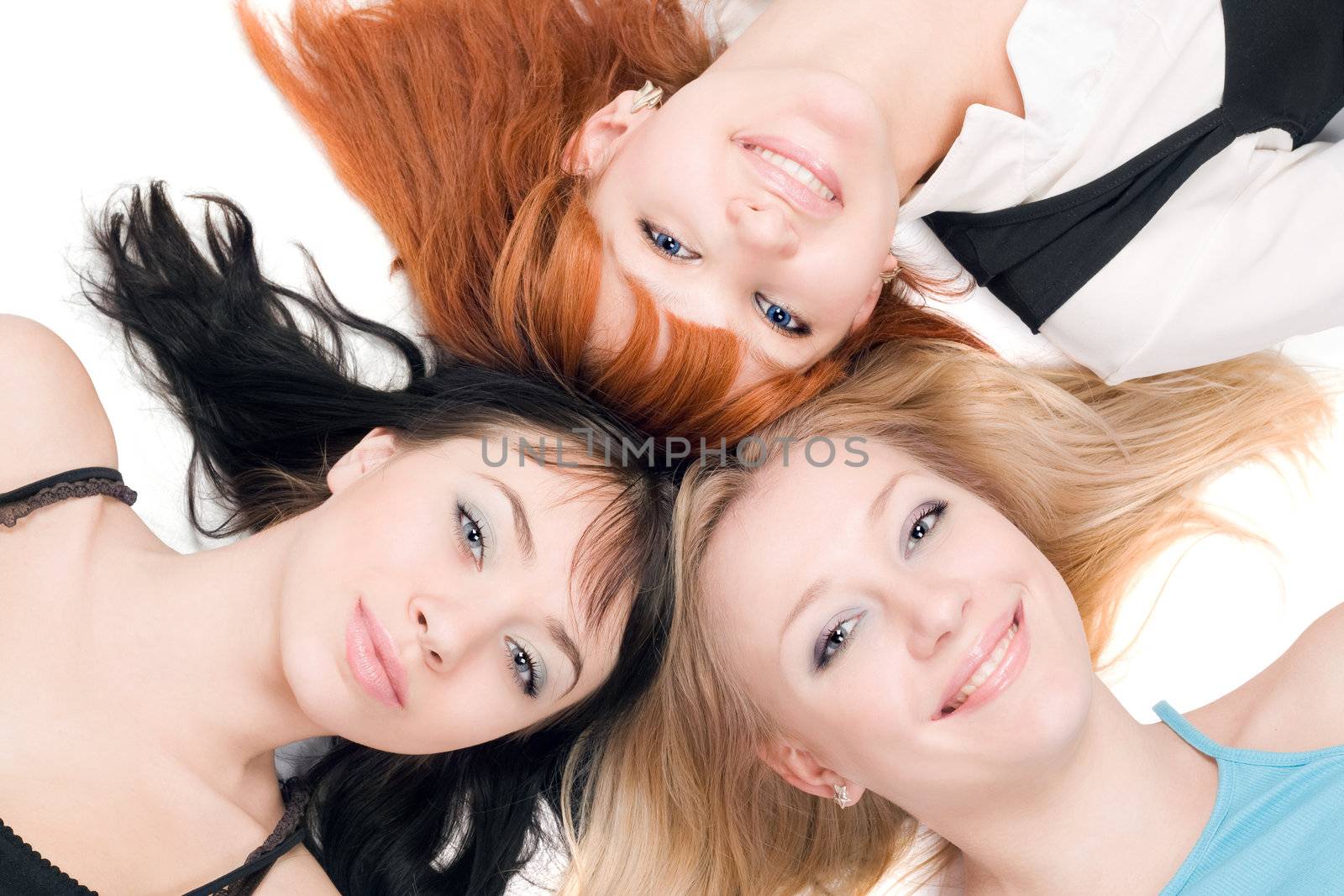 Portrait of three young cheerful women on white background