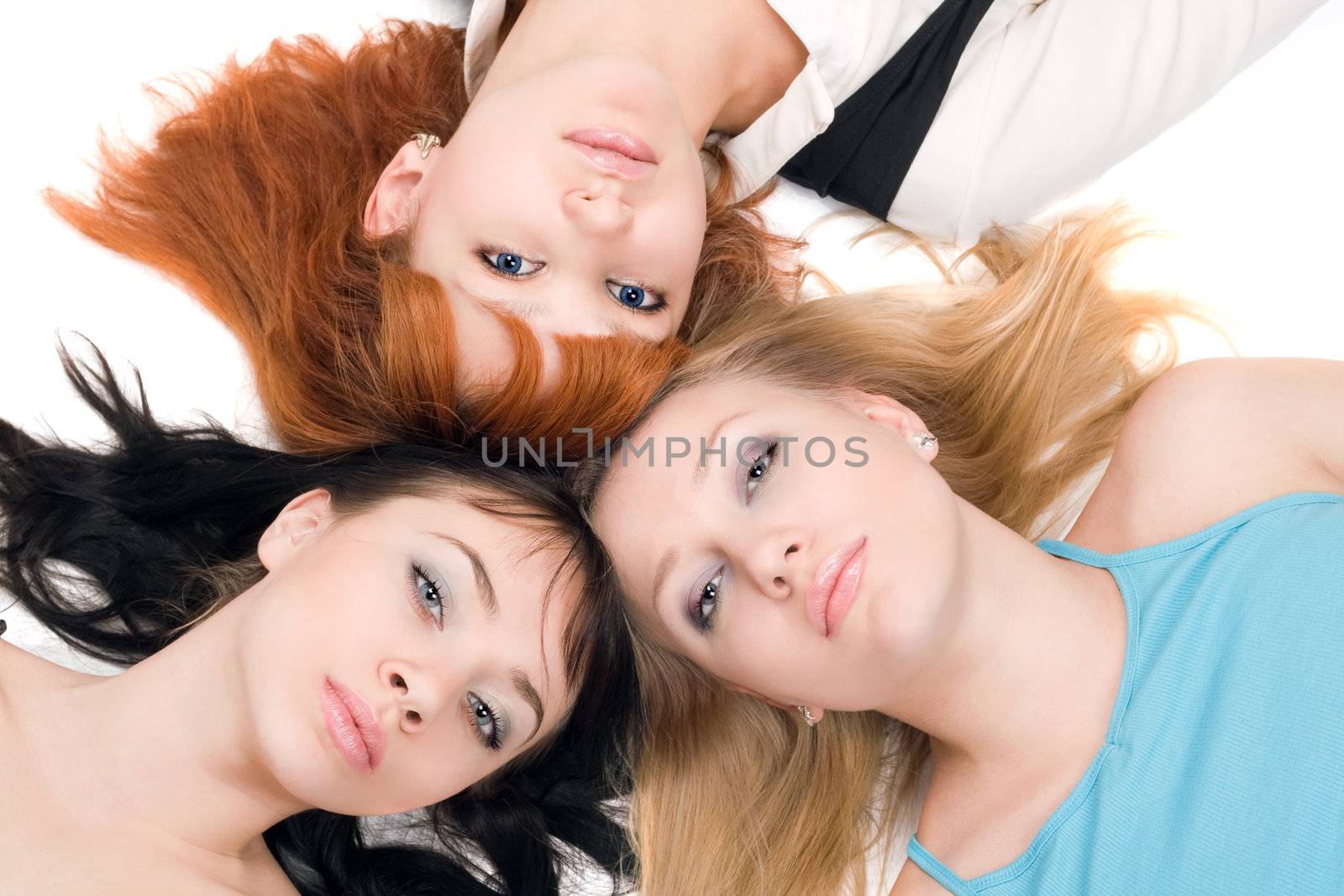 Portrait of three young women lying on white background