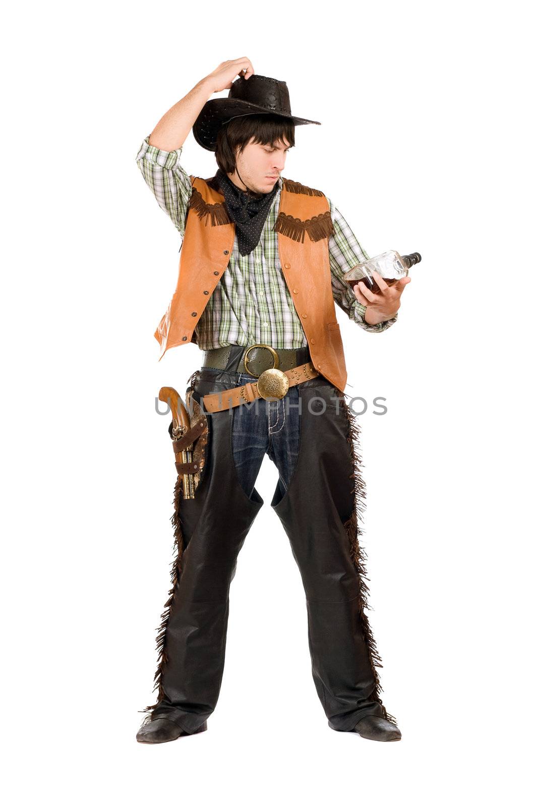 Pensive young cowboy with a bottle of whiskey in hand