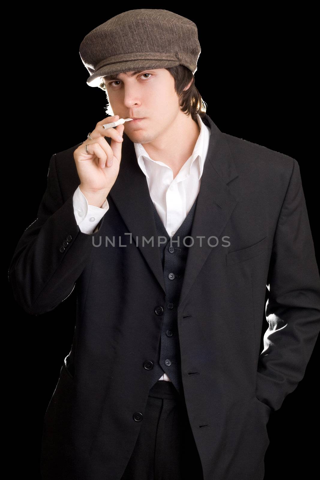 Old-fashioned man with a cigarette. Isolated on black