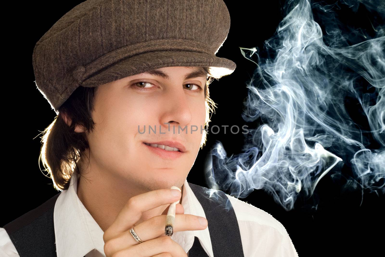 Portrait of a young man with a cigarette. Isolated on black