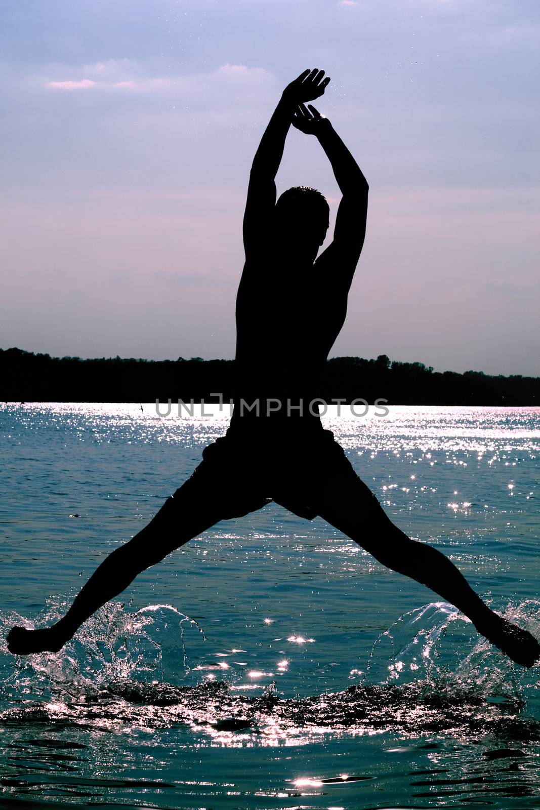 Silhouette of a man jumping in the river