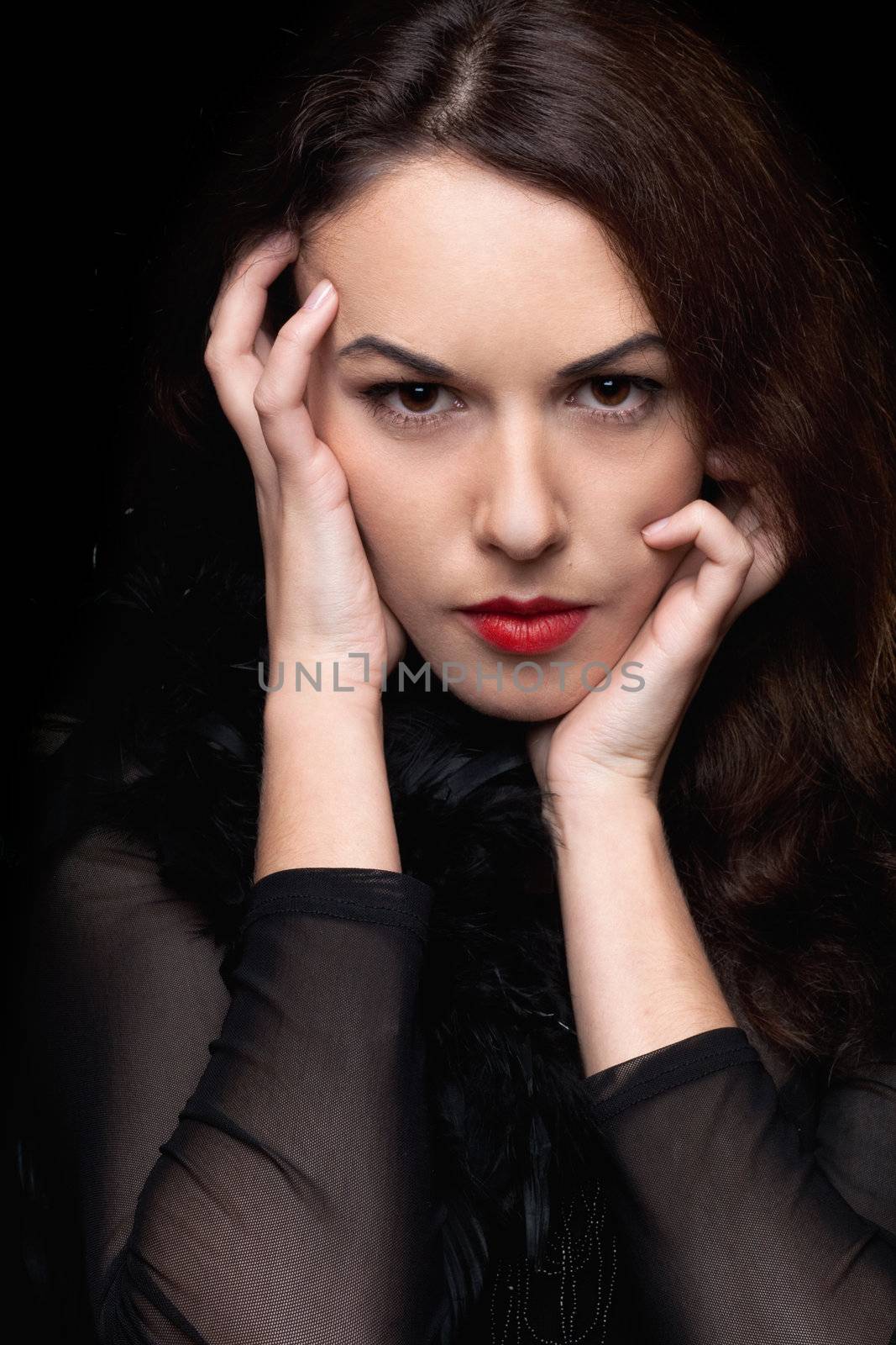 Closeup portrait of mysterious young woman. Isolated on black