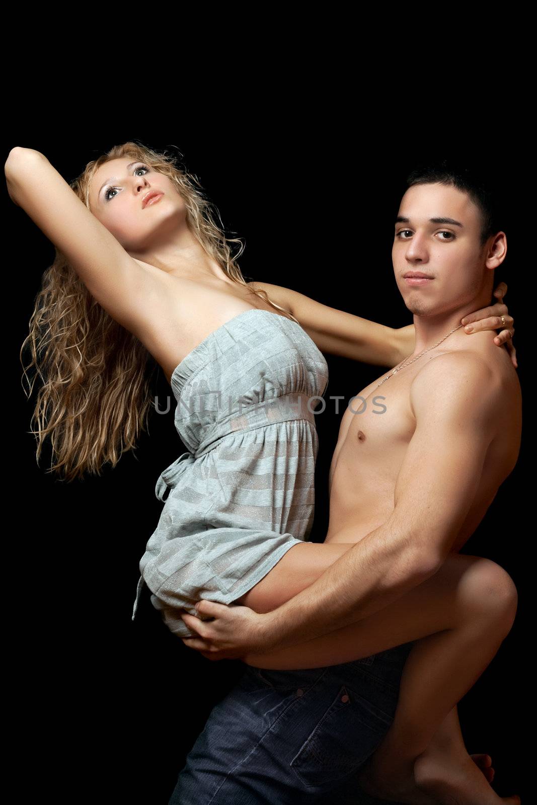 Young man holds a beautiful blonde on his hands