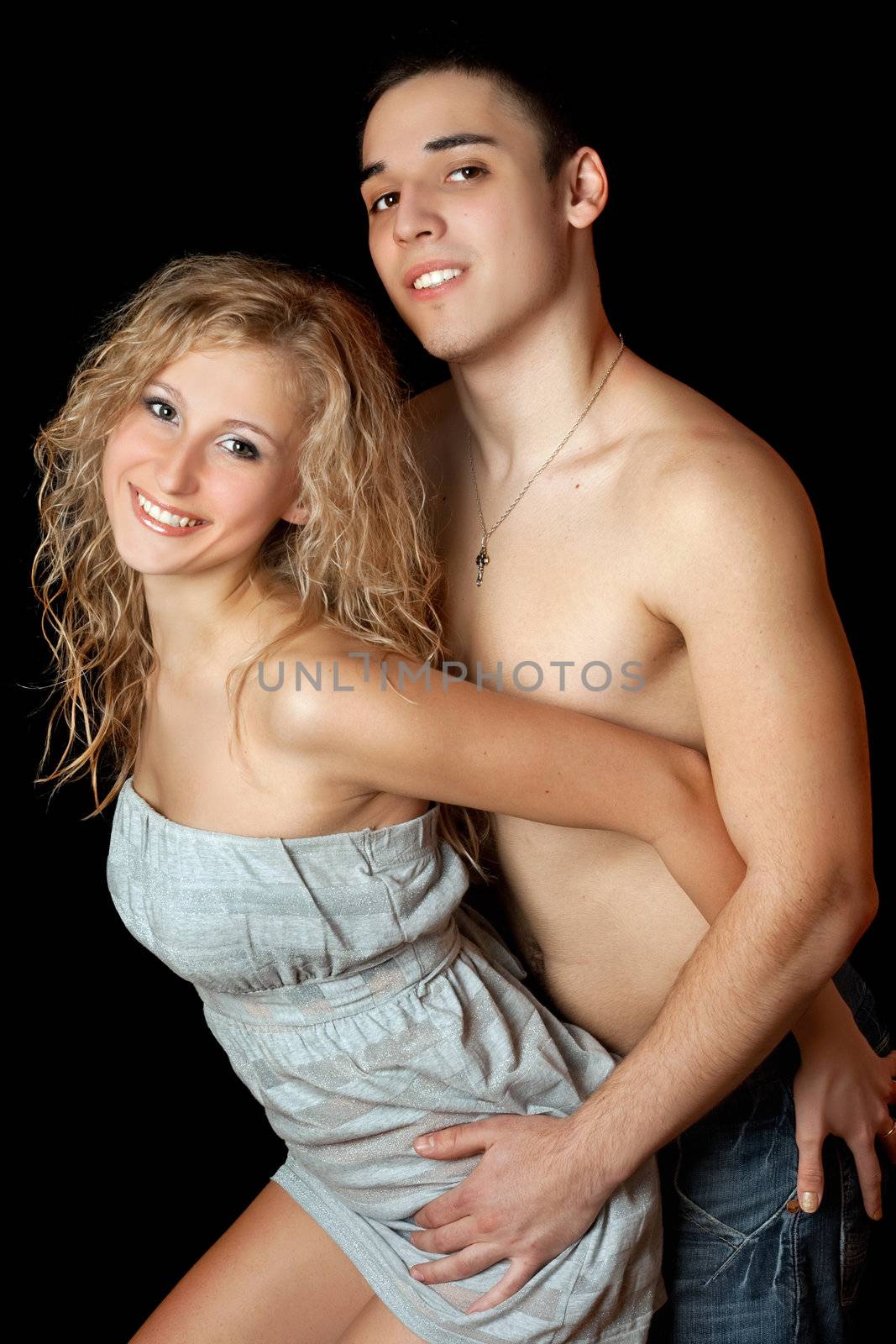 Portrait of cheerful beautiful young couple. Isolated on black