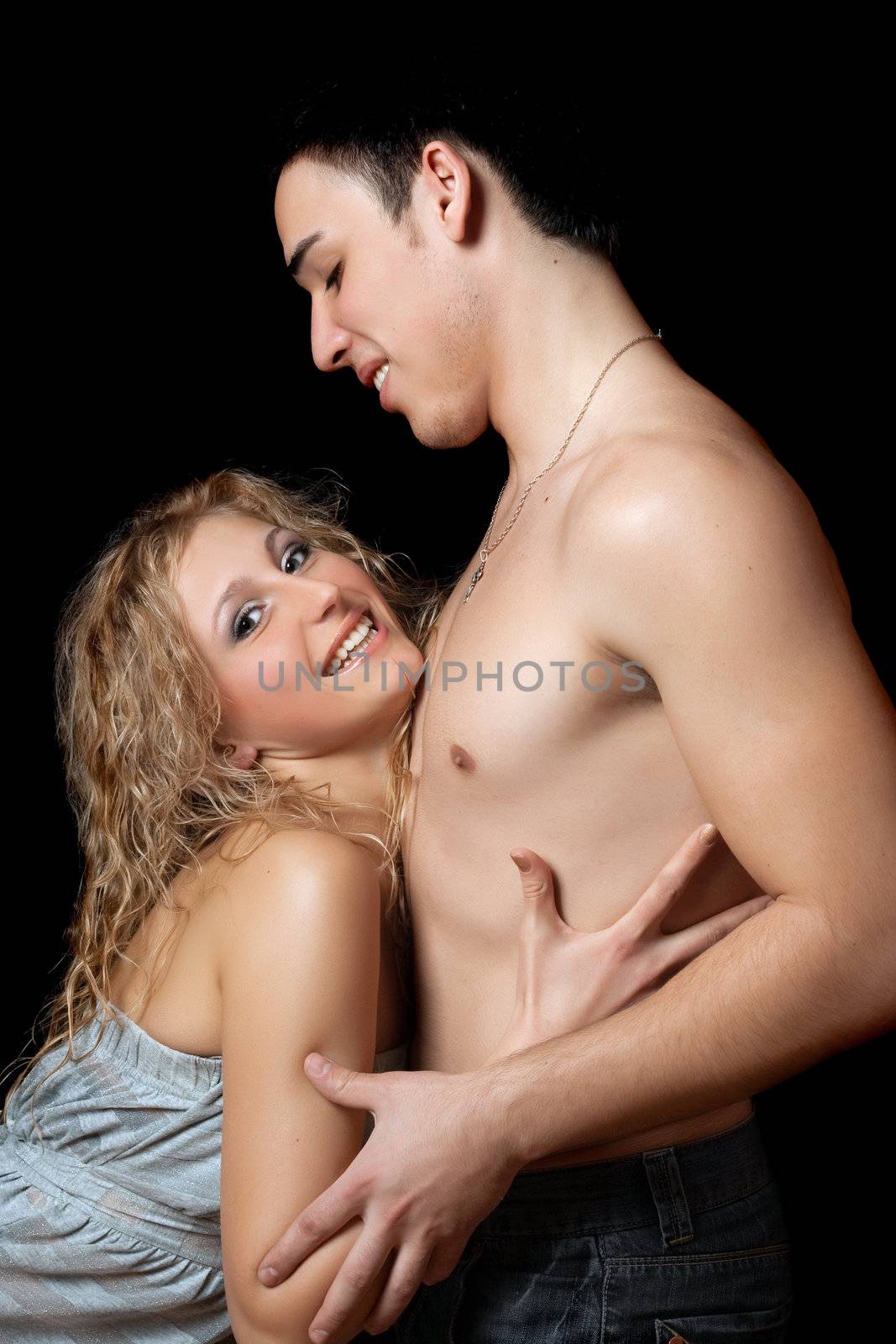 Portrait of joyful beautiful young couple. Isolated on black