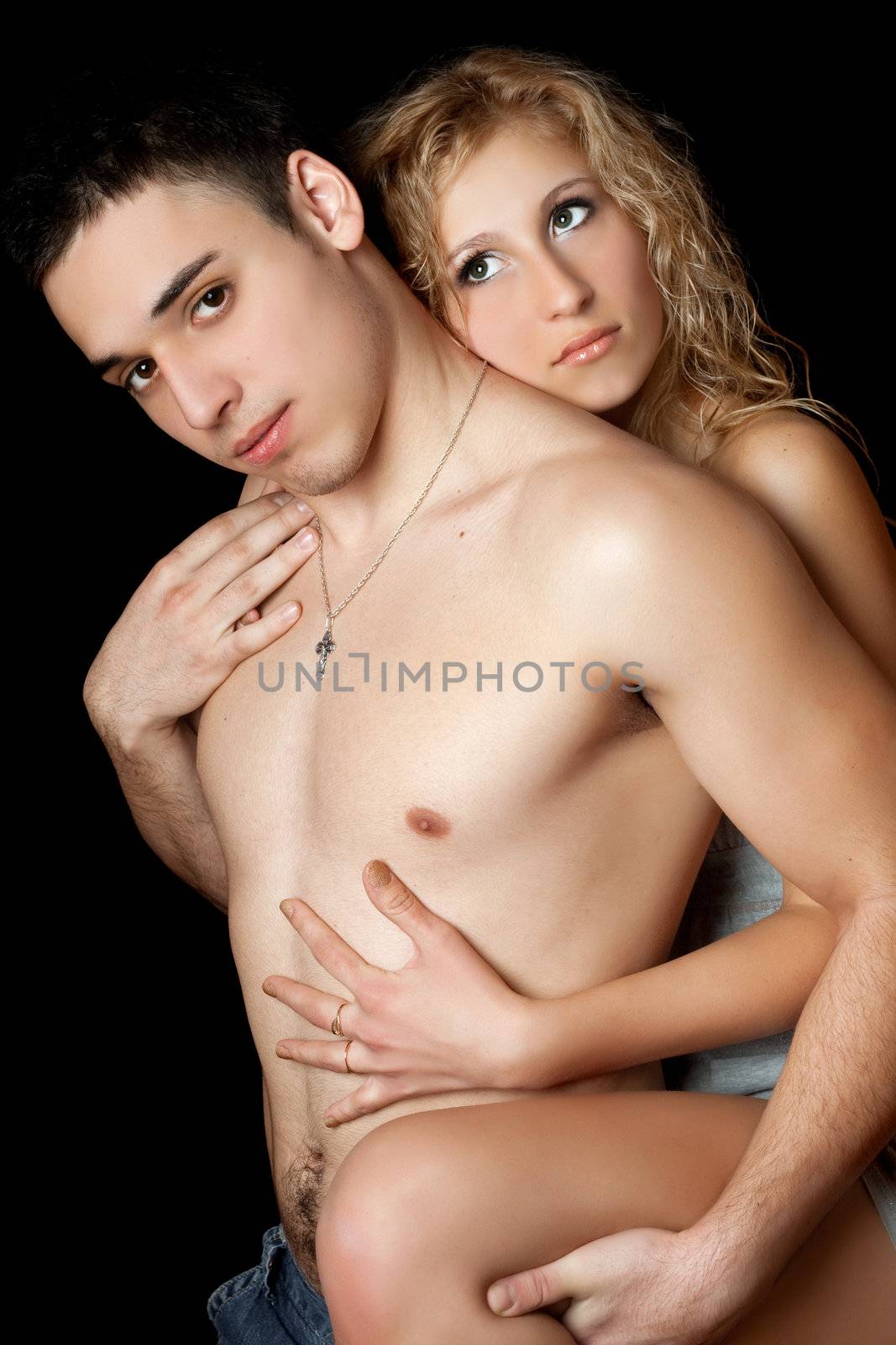 Portrait of attractive loving young couple. Isolated on black