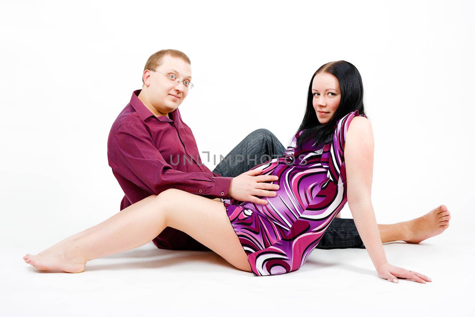 Young couple. A pregnant woman in a dress and a man. studio photography