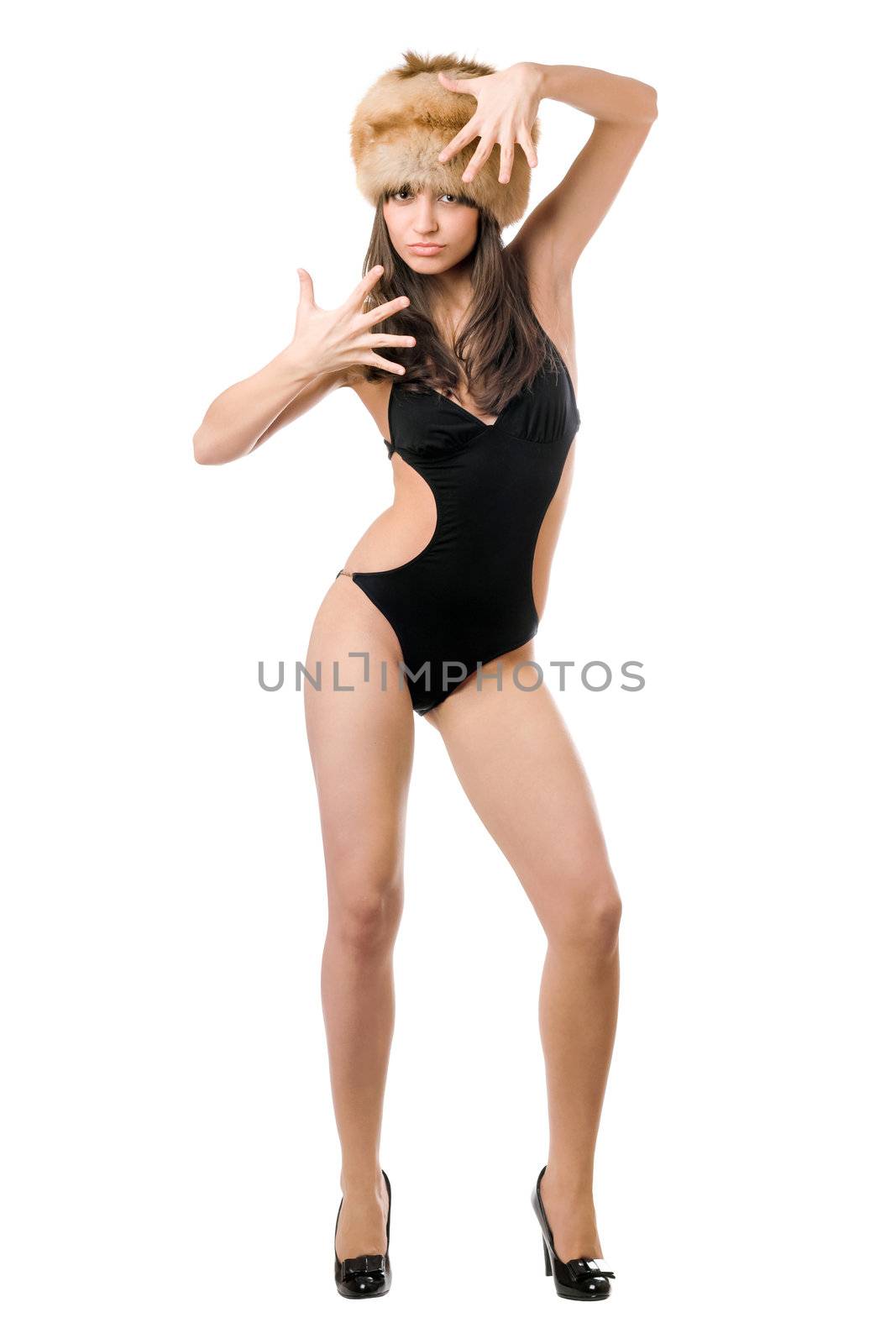 Pretty lady posing in black swimsuit and fur-cap. Isolated on white
