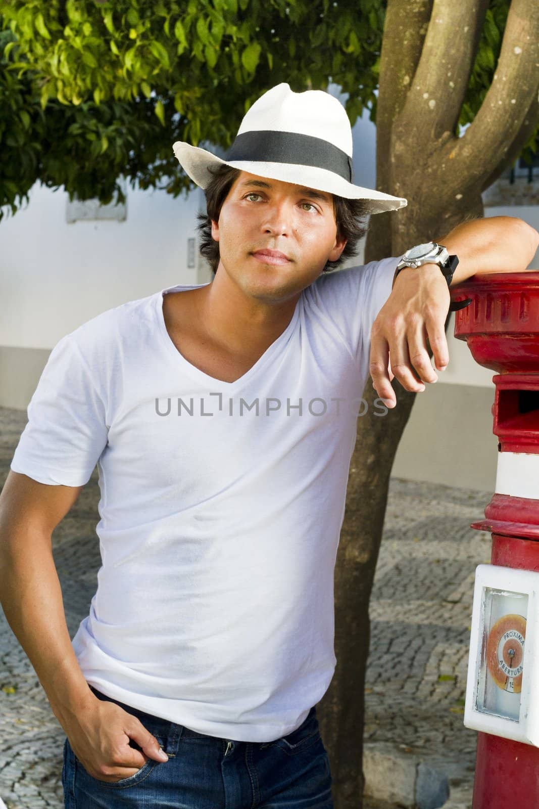 View of a handsome man with white shirt and hat on a urban city.