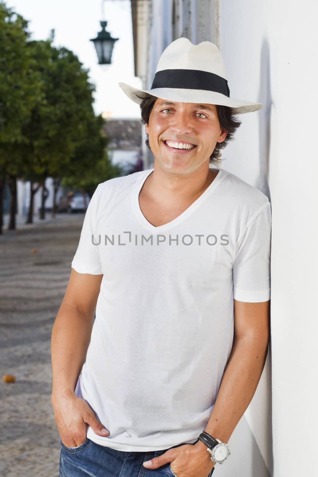 View of a handsome man with white shirt and hat on a urban city.