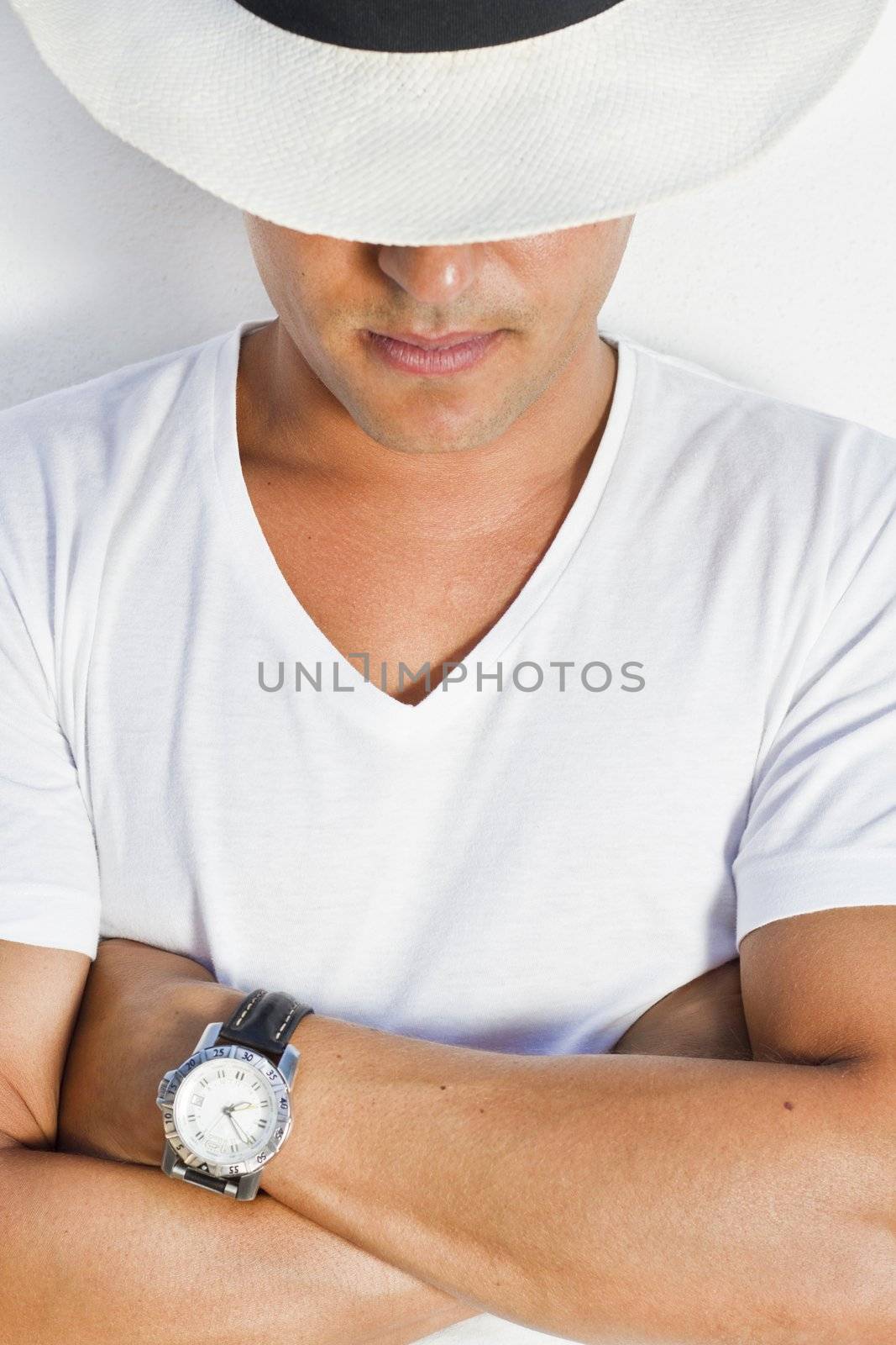 View of a handsome man with white shirt and hat on a urban city.