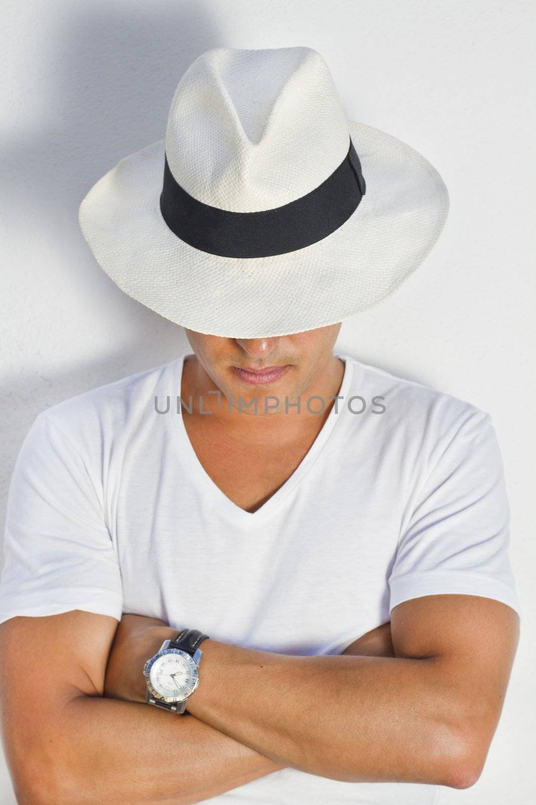 View of a handsome man with white shirt and hat on a urban city.