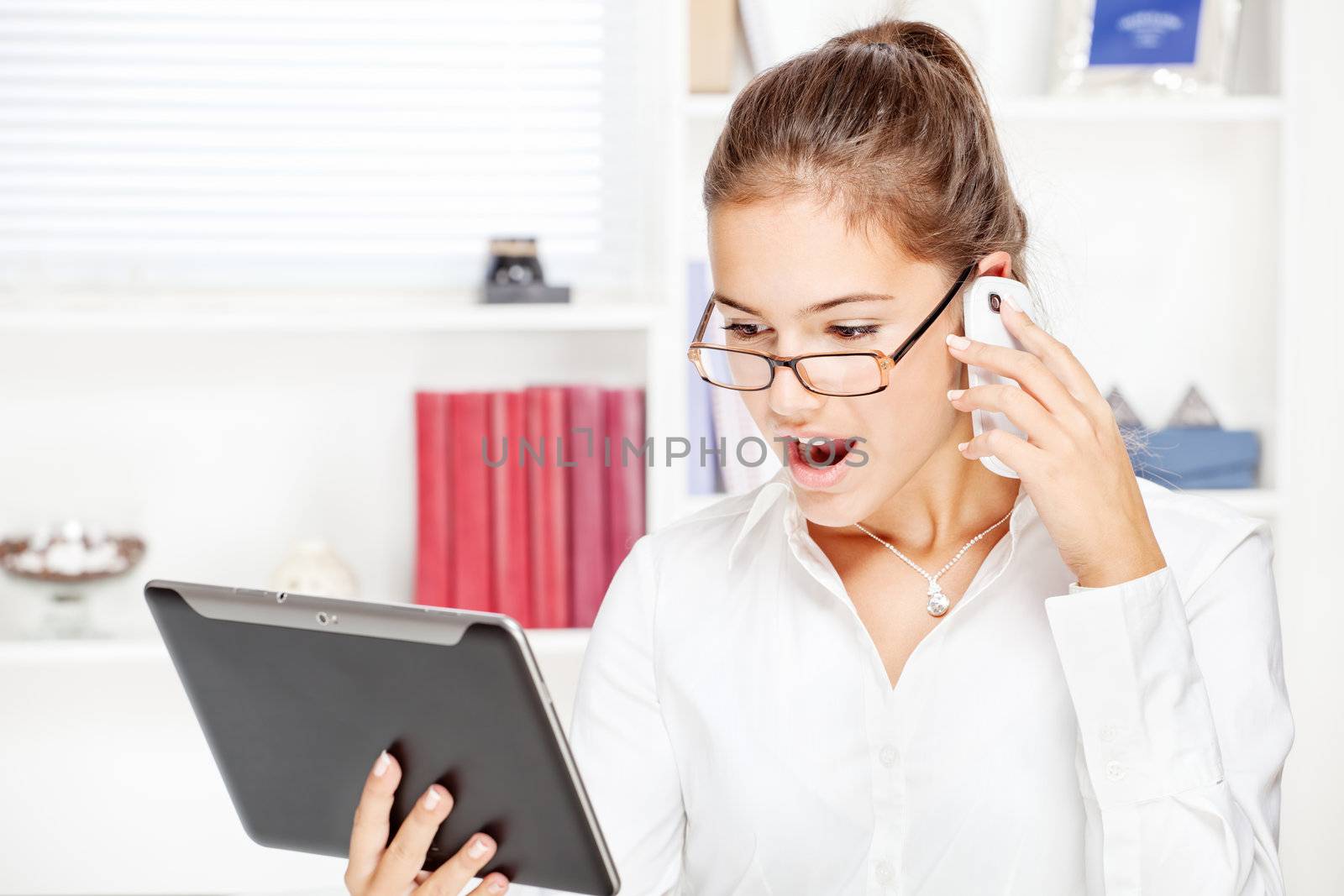 surprised businesswoman looking at tablet computer by imarin