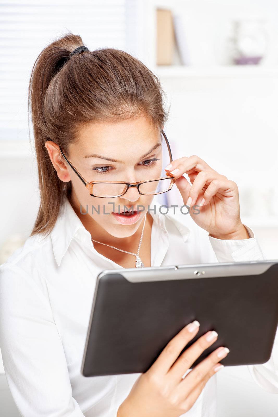 surprised businesswoman looking at tablet computer by imarin