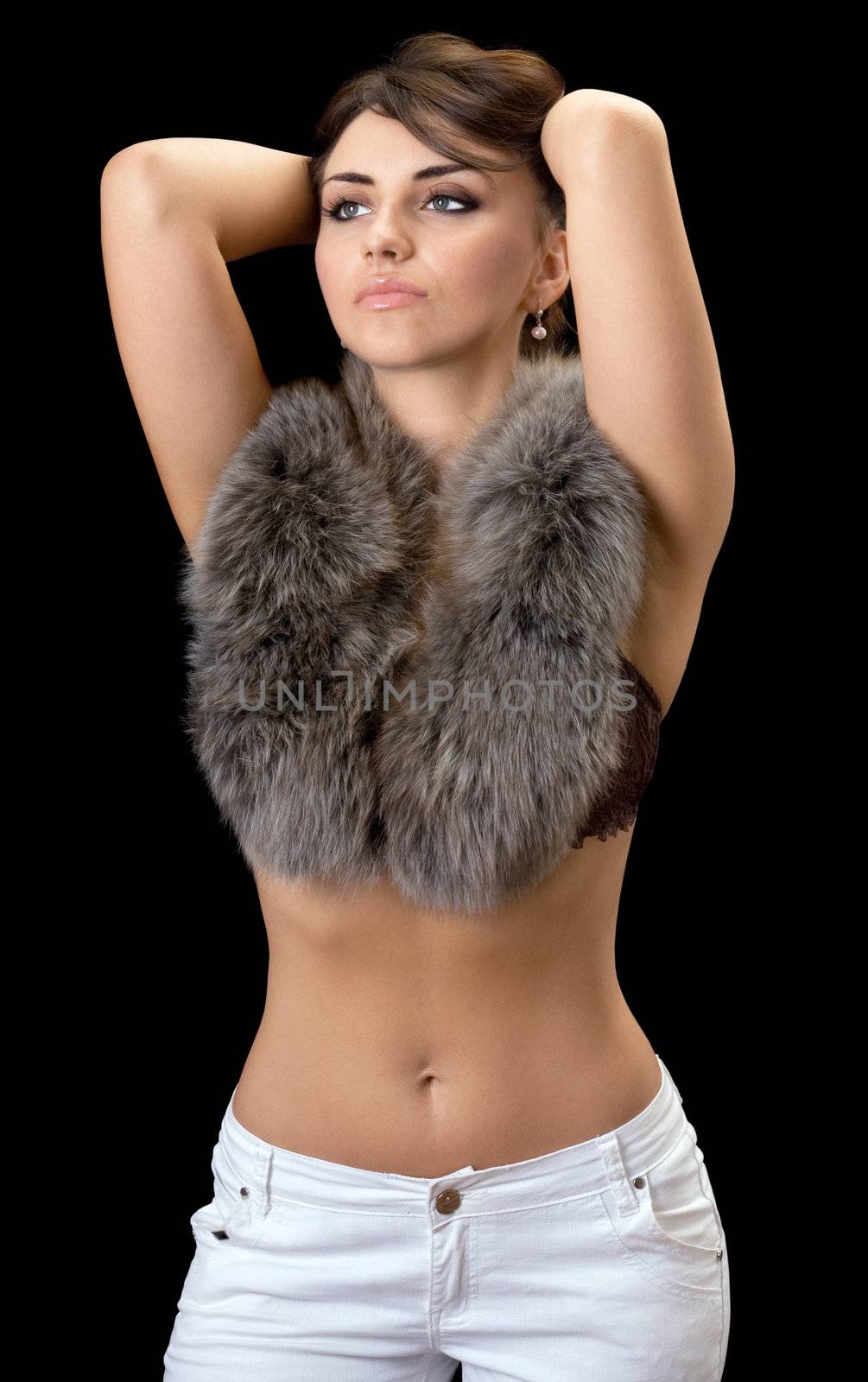 Attractive brunette posing in fur. Isolated on black