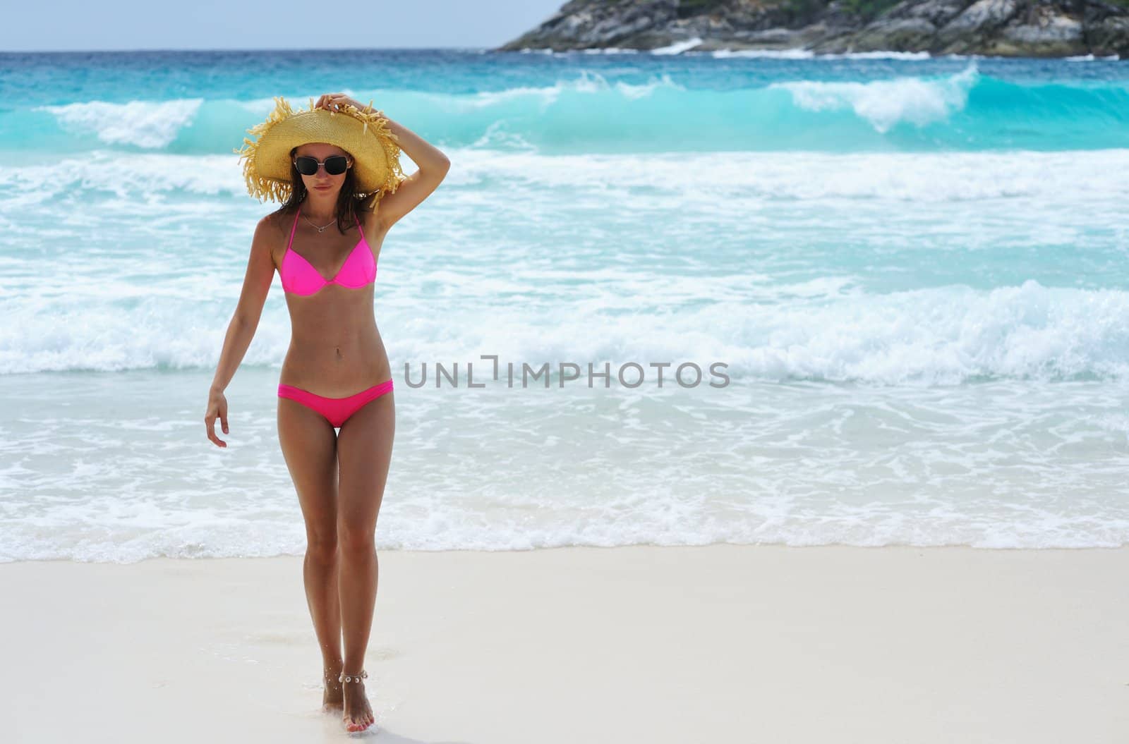 Girl on a tropical beach with hat