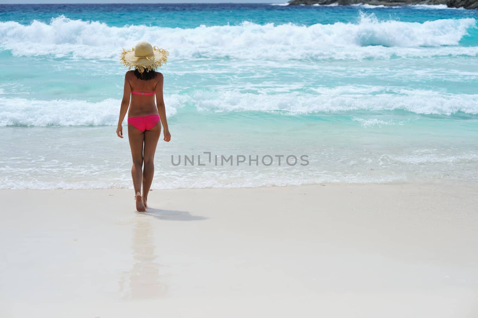 Girl on a tropical beach with hat