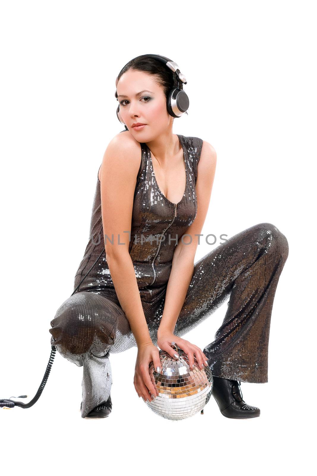 Sexy young brunette in headphones with a mirror ball