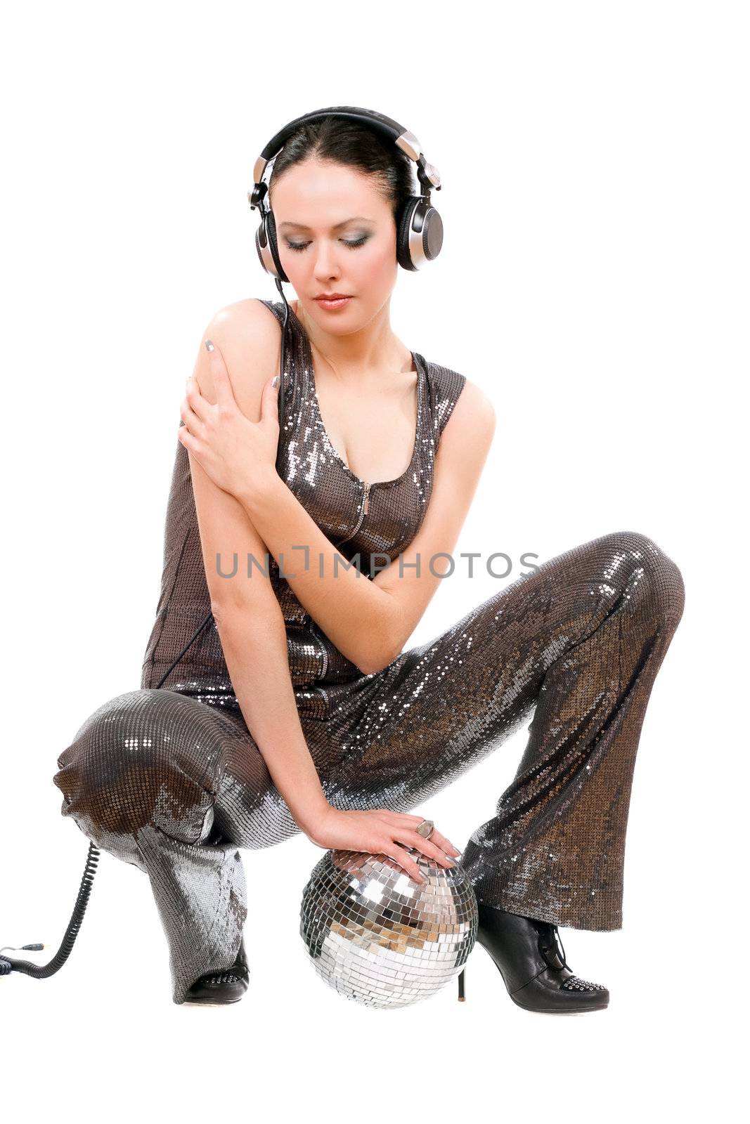 Nice young brunette in headphones with a mirror ball. Isolated